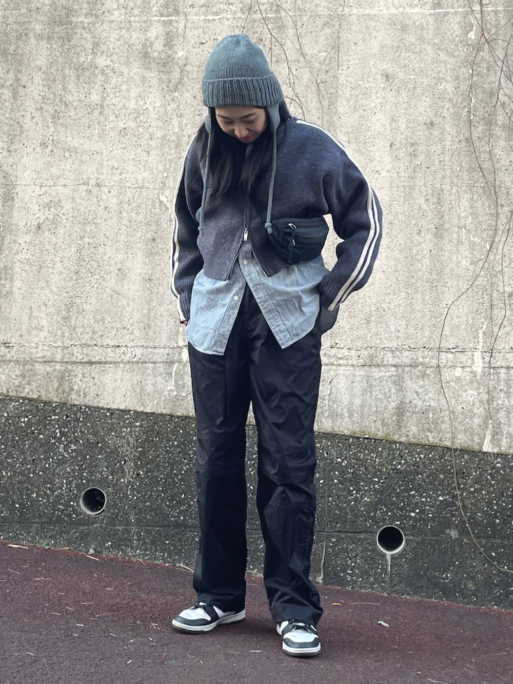 グレー系のニット/セーター、ホワイト系のスニーカー、グレー系のニットキャップ/ビーニーを着用したレディースの冬コーディネートの5枚目の写真
