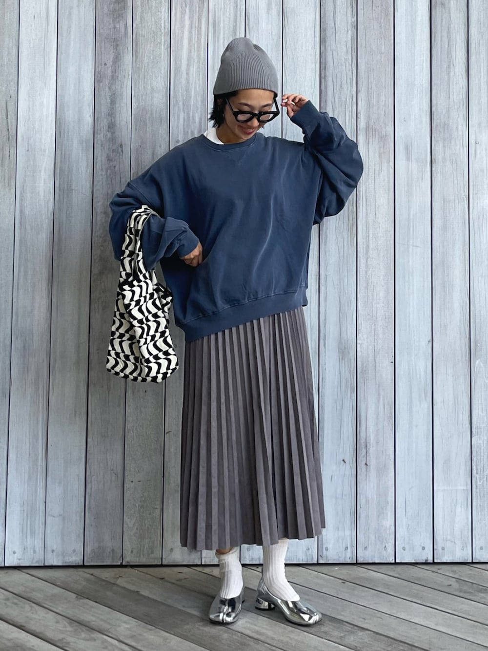 ブルー系のスウェット、グレー系のスカート、ブラック系のトートバッグを着用したレディースの秋コーディネートの3枚目の写真