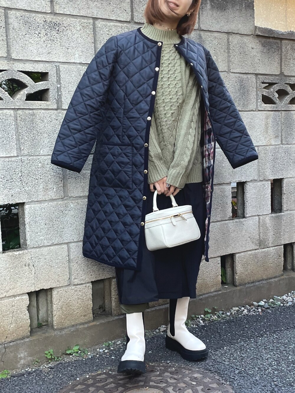 グリーン系のニット/セーター、ブルー系のノーカラーコート、ブラック系のワンピースを着用したレディースの秋コーディネートの2枚目の写真