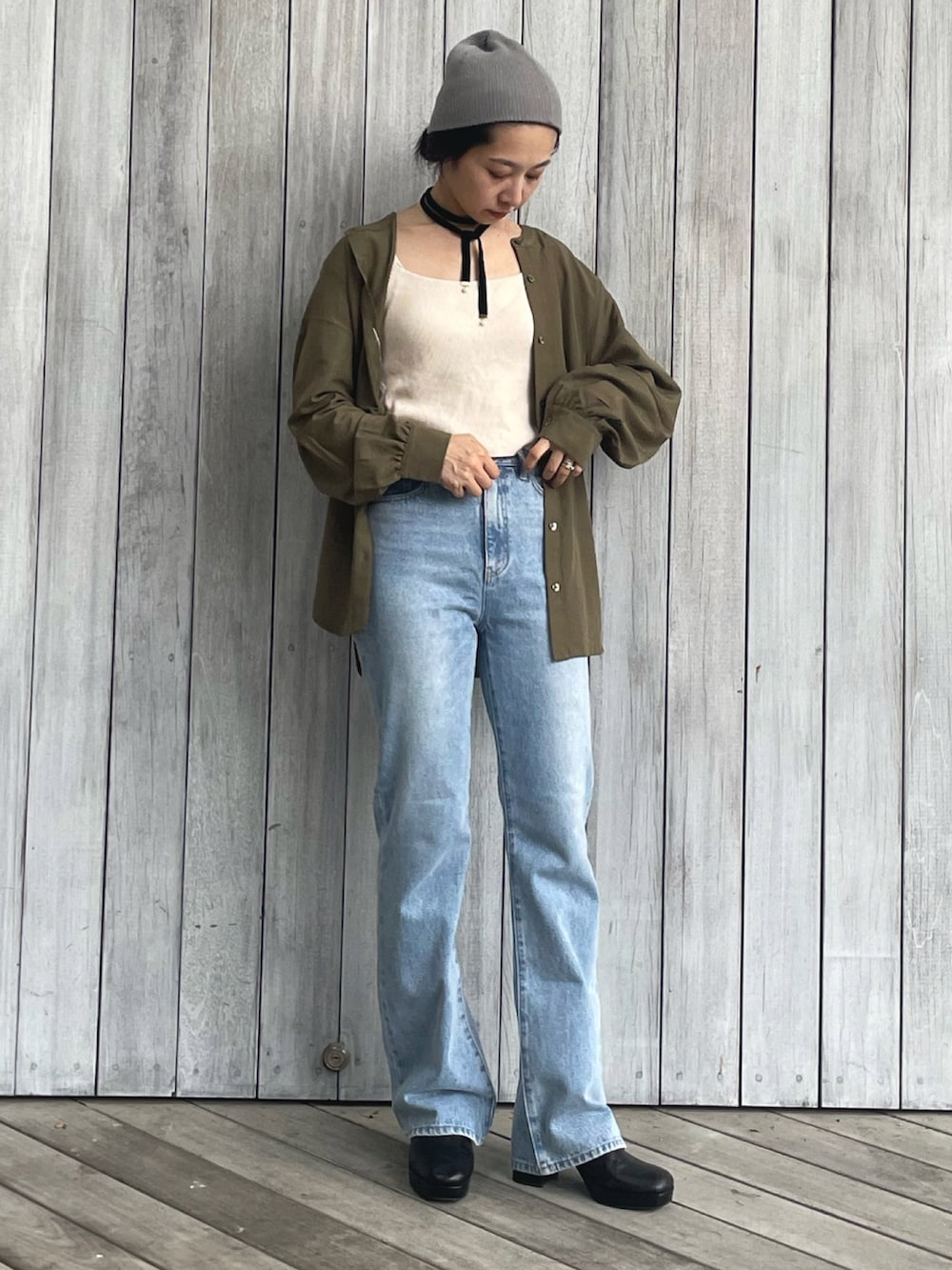 グリーン系のシャツ/ブラウス、ブルー系のデニムパンツ、ブラック系のサンダルを着用したレディースの秋コーディネートの2枚目の写真