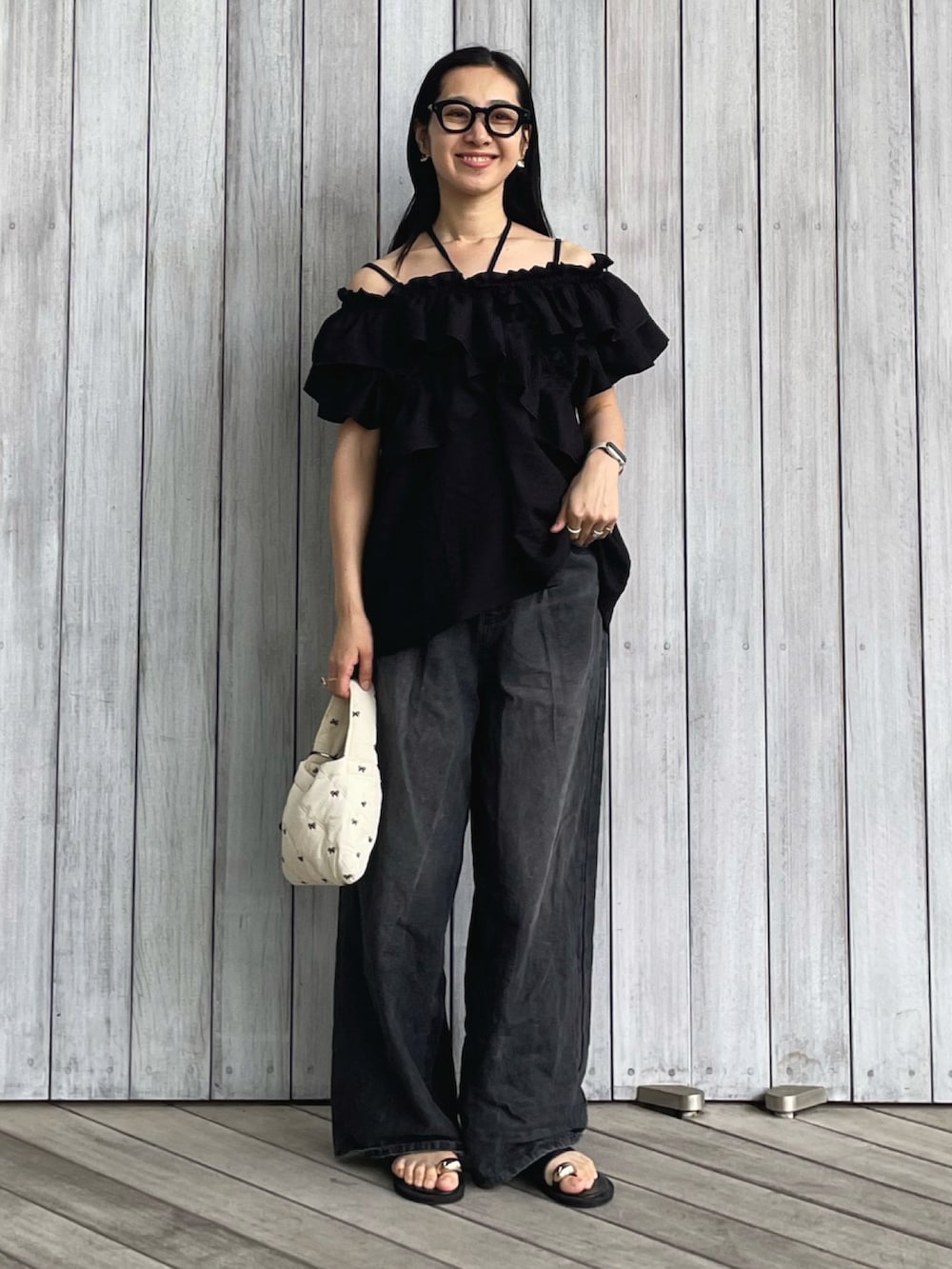 ブラック系のシャツ/ブラウス、ブラック系のデニムパンツ、ブラック系のサンダルを着用したレディースの春コーディネートの5枚目の写真