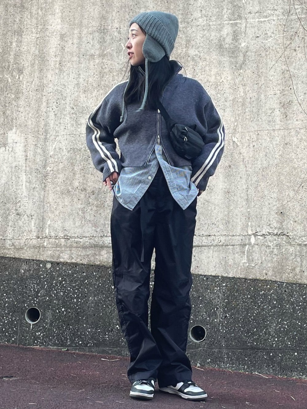 グレー系のニット/セーター、ホワイト系のスニーカー、グレー系のニットキャップ/ビーニーを着用したレディースの冬コーディネートの4枚目の写真