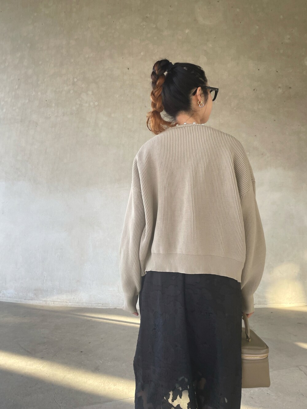 ベージュ系のカーディガン/ボレロ、ブラック系のワンピース、ブラック系のサンダルを着用したレディースの春コーディネートの5枚目の写真