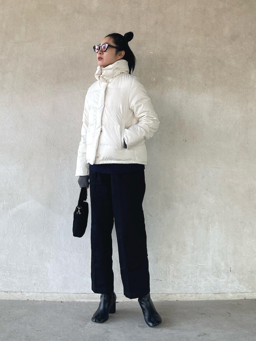 ホワイト系のダウンジャケット/コート、ブルー系のベスト、ブラック系のデニムパンツを着用したレディースの冬コーディネートの4枚目の写真
