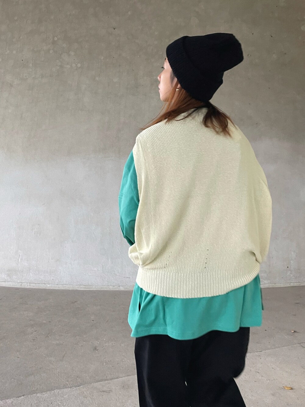 ホワイト系のベスト、グリーン系のTシャツ/カットソー、ブラック系のカーゴパンツを着用したレディースの秋コーディネートの4枚目の写真