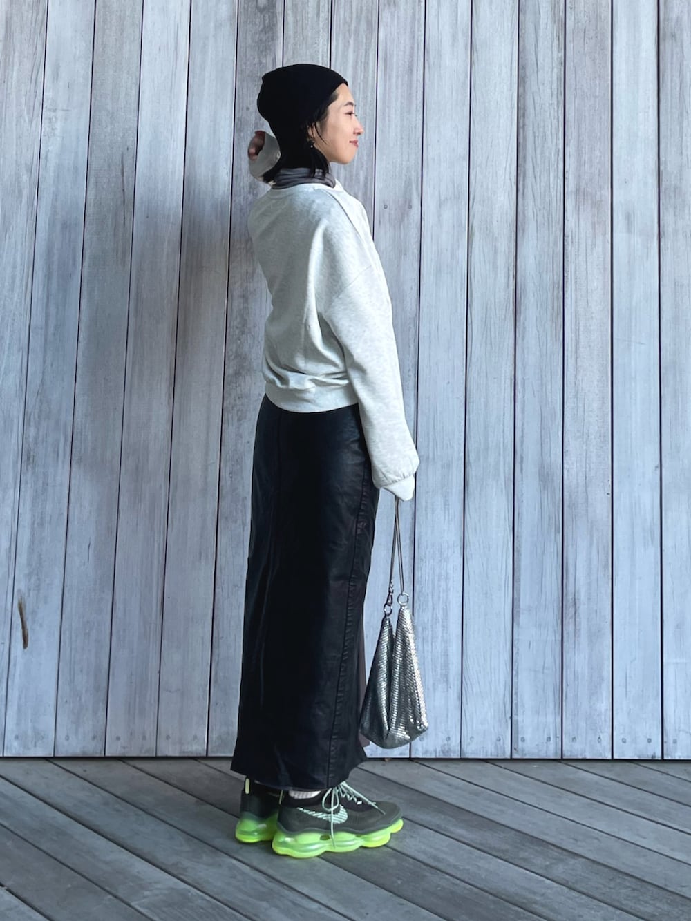 ベージュ系のスウェット、ブラック系のスカート、グリーン系のスニーカーを着用したレディースの冬コーディネートの4枚目の写真