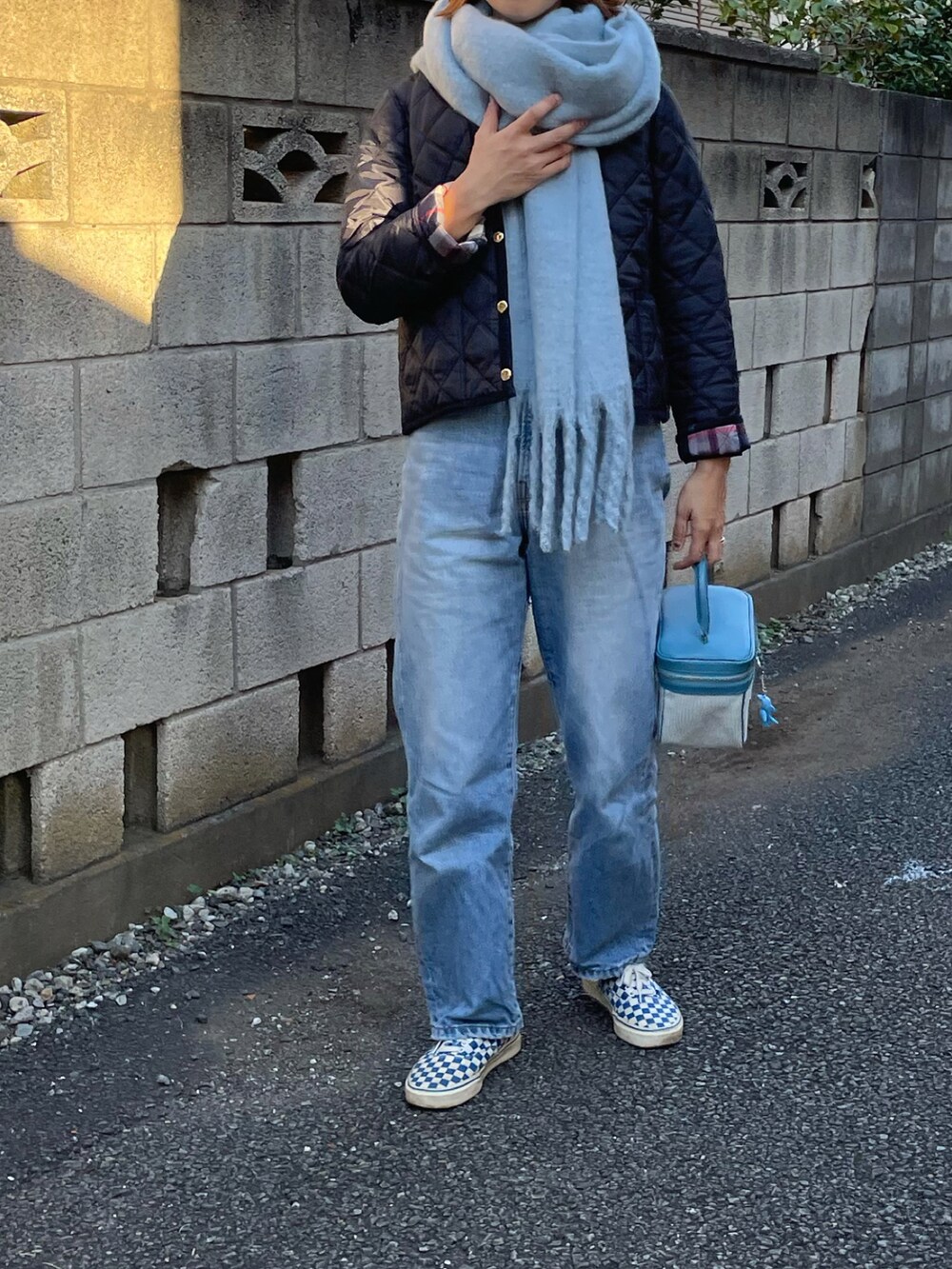 ブルー系のブルゾン、ブルー系のハンドバッグ、ブルー系のスニーカーを着用したレディースの秋コーディネートの3枚目の写真