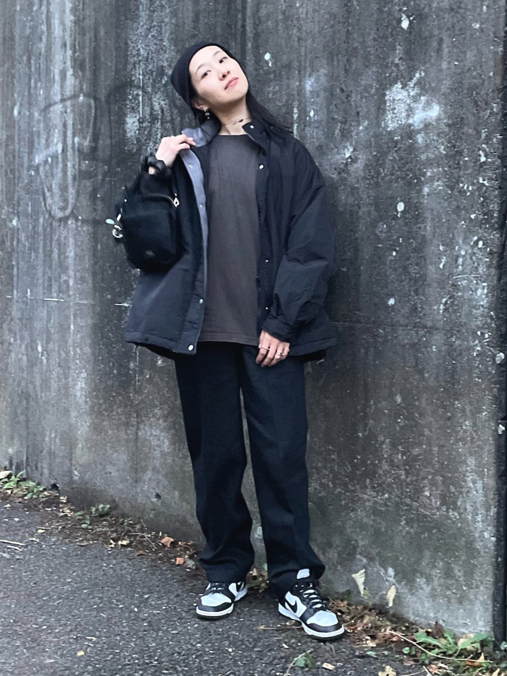 ブラック系のブルゾン、グレー系のTシャツ/カットソー、ブラック系のデニムパンツを着用したレディースの秋コーディネートの4枚目の写真