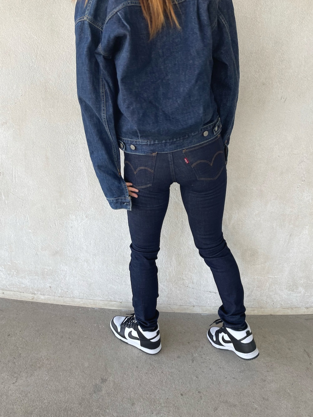 ブルー系のデニムパンツ、ホワイト系のスニーカーを着用したレディースの春コーディネートの4枚目の写真