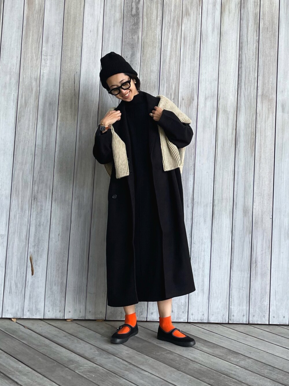 ブラック系のチェスターコート、ブラック系のワンピース、グリーン系のニット/セーターを着用したレディースの秋コーディネートの4枚目の写真