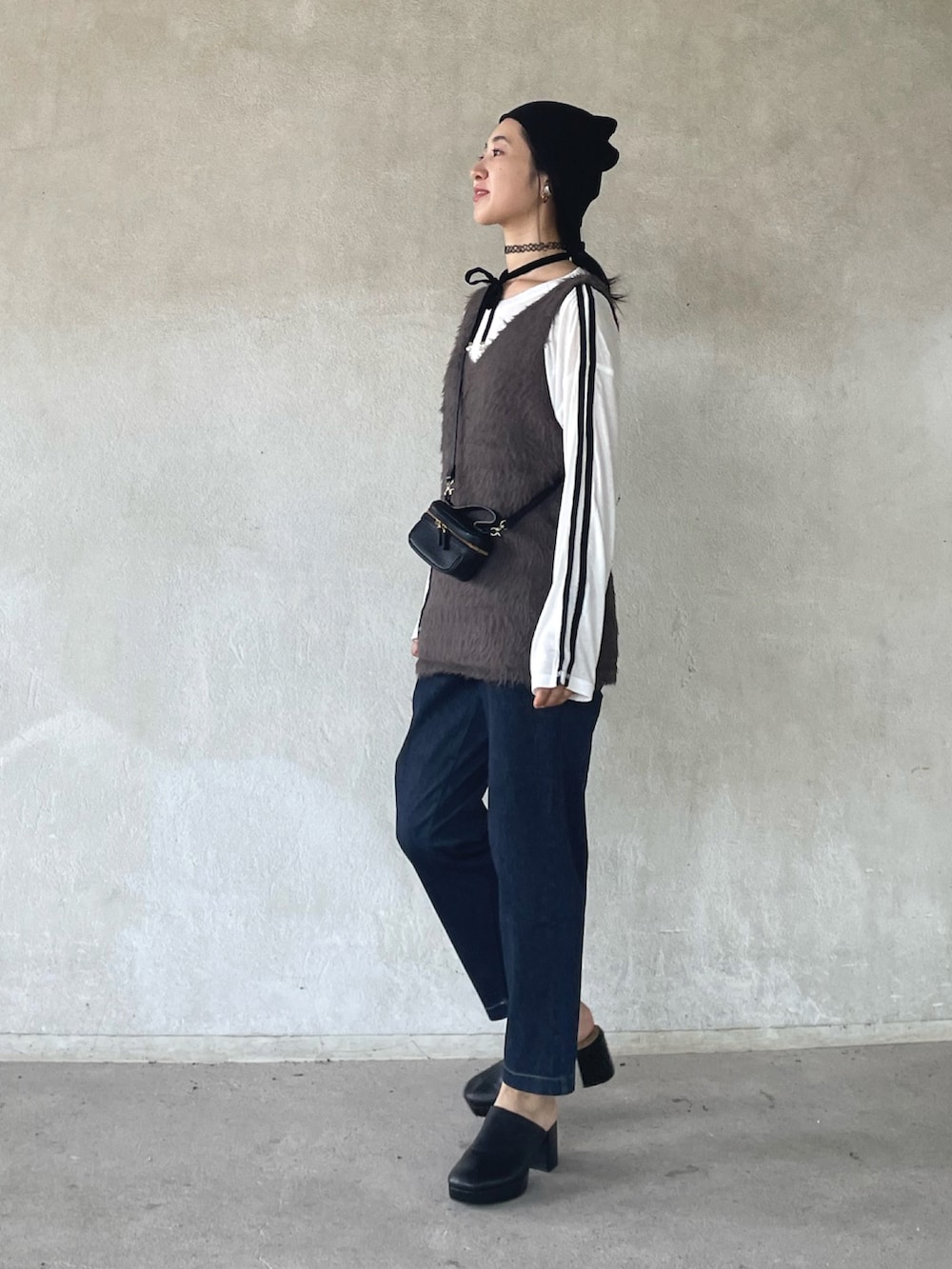 グレー系のベスト、ホワイト系のTシャツ/カットソー、ブルー系のその他パンツを着用したレディースの秋コーディネートの2枚目の写真