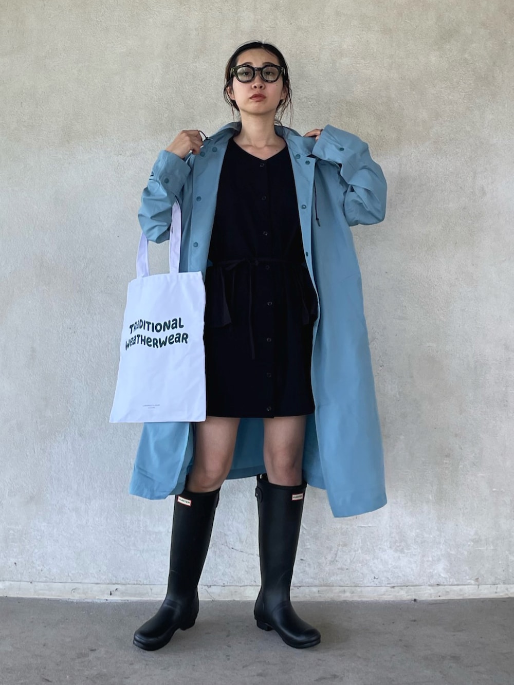 ホワイト系のトートバッグ、その他のチュニック、ブラック系のレインシューズを着用したレディースの春コーディネートの3枚目の写真