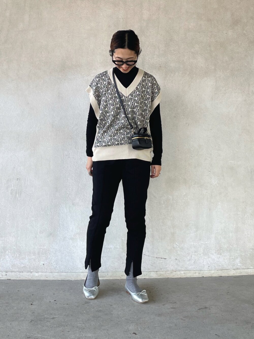 ホワイト系のベスト、ブラック系のスウェットパンツ、シルバー系のバレエシューズを着用したレディースの春コーディネートの2枚目の写真
