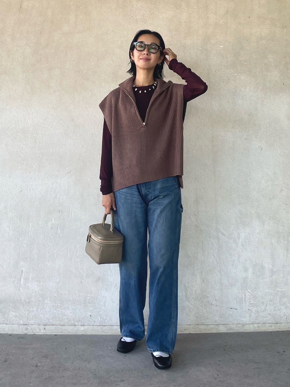 ブラウン系のベスト、ブラウン系のTシャツ/カットソー、ブルー系のデニムパンツを着用したレディースの秋コーディネートの2枚目の写真