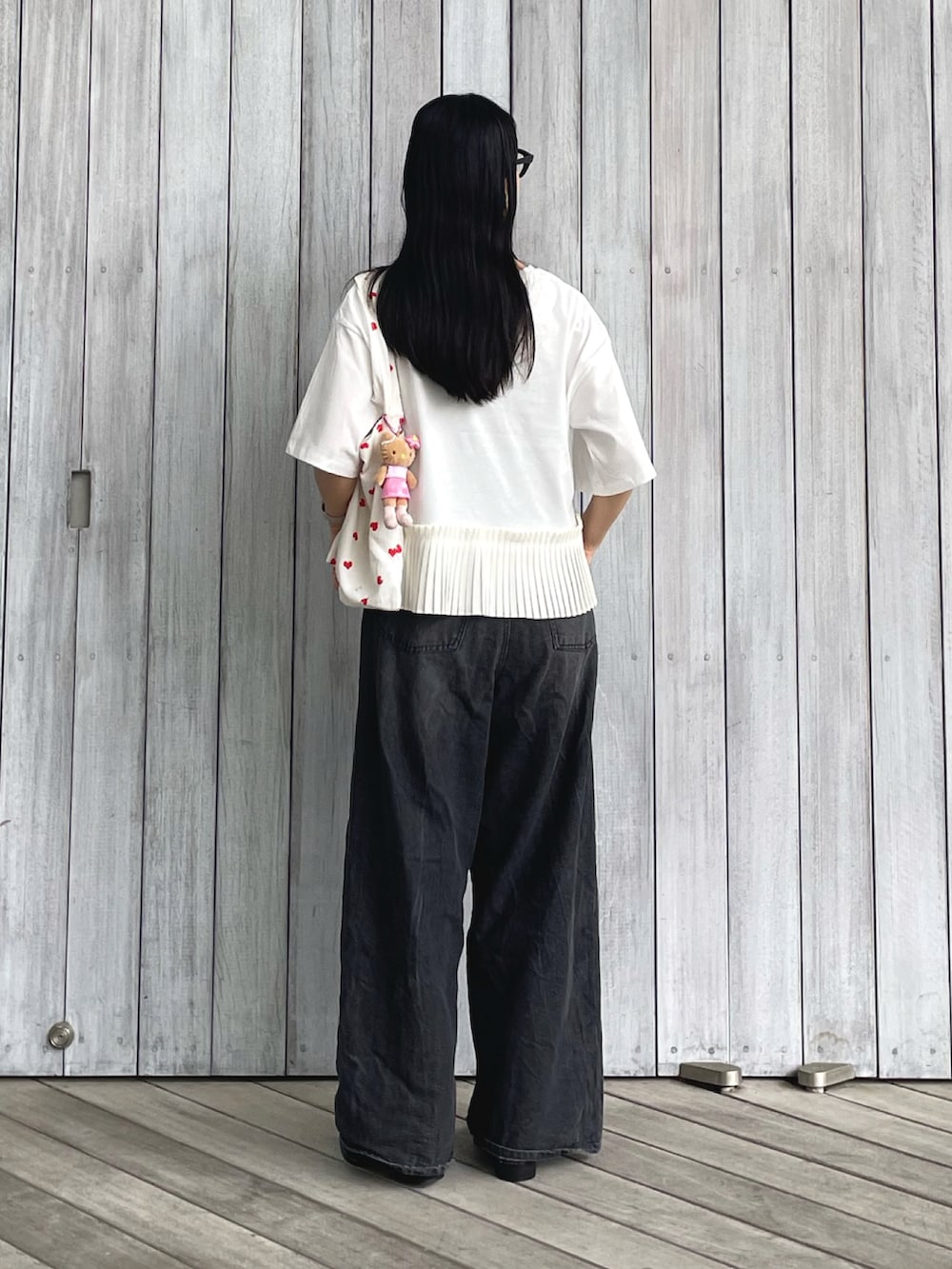 ホワイト系のTシャツ/カットソー、ブラック系のデニムパンツ、ブラック系のパンプスを着用したレディースの春コーディネートの2枚目の写真