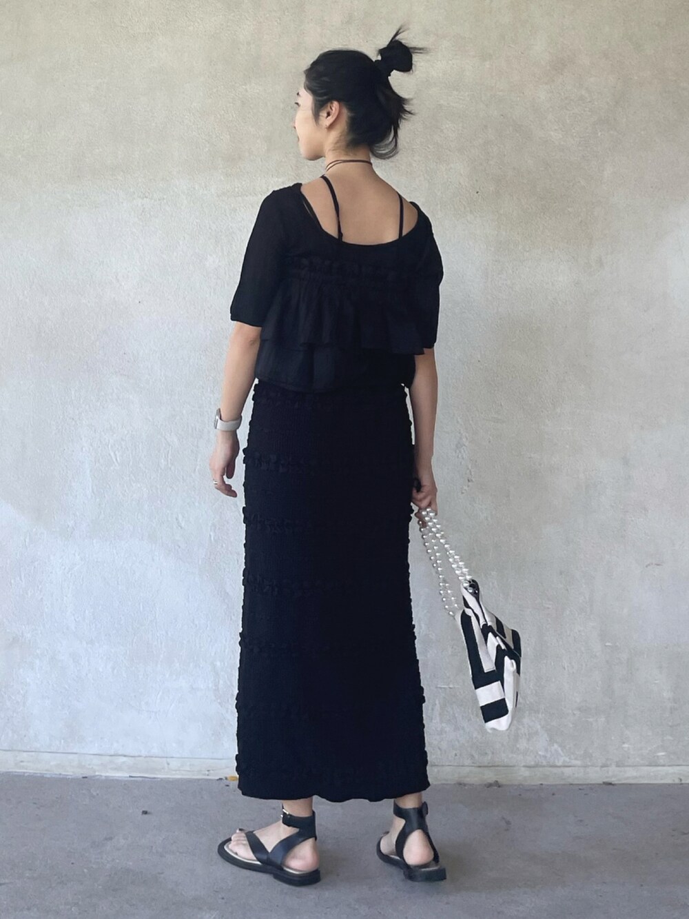 ブラック系のニット/セーター、ブラック系のキャミソール、ブラック系のスカートを着用したレディースの夏コーディネートの3枚目の写真