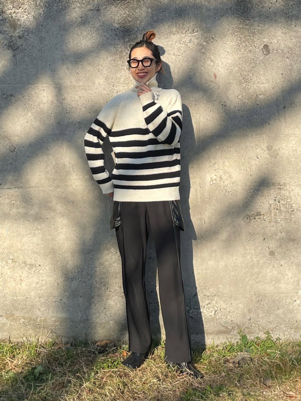 グリーン系のMA-1、ホワイト系のニット/セーター、ブラック系のその他パンツを着用したレディースの冬コーディネートの2枚目の写真