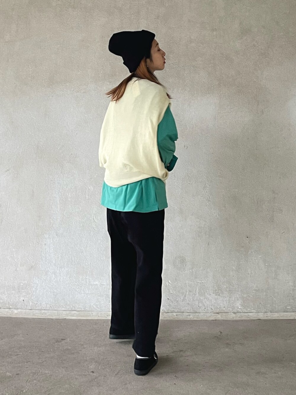 ホワイト系のベスト、グリーン系のTシャツ/カットソー、ブラック系のカーゴパンツを着用したレディースの秋コーディネートの2枚目の写真