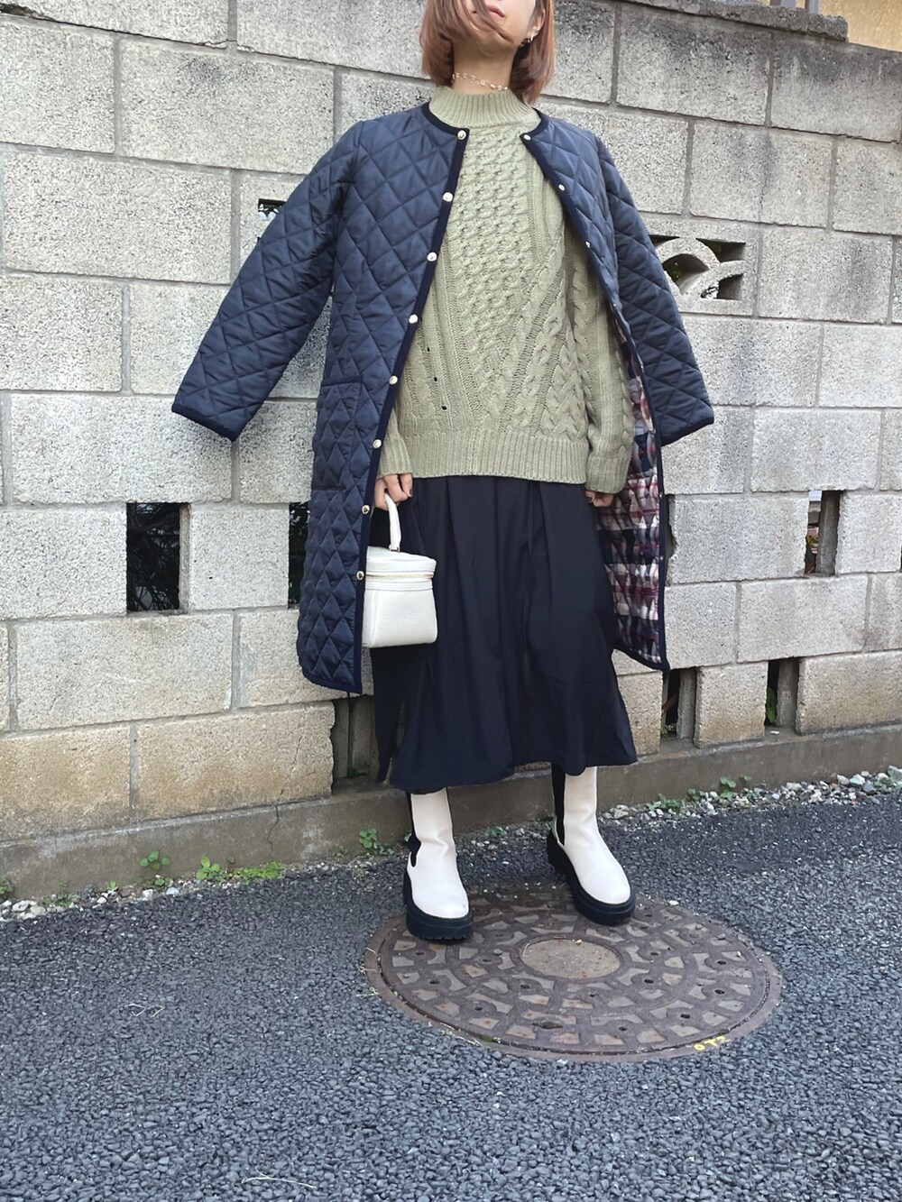 グリーン系のニット/セーター、ブルー系のノーカラーコート、ブラック系のワンピースを着用したレディースの秋コーディネートの3枚目の写真