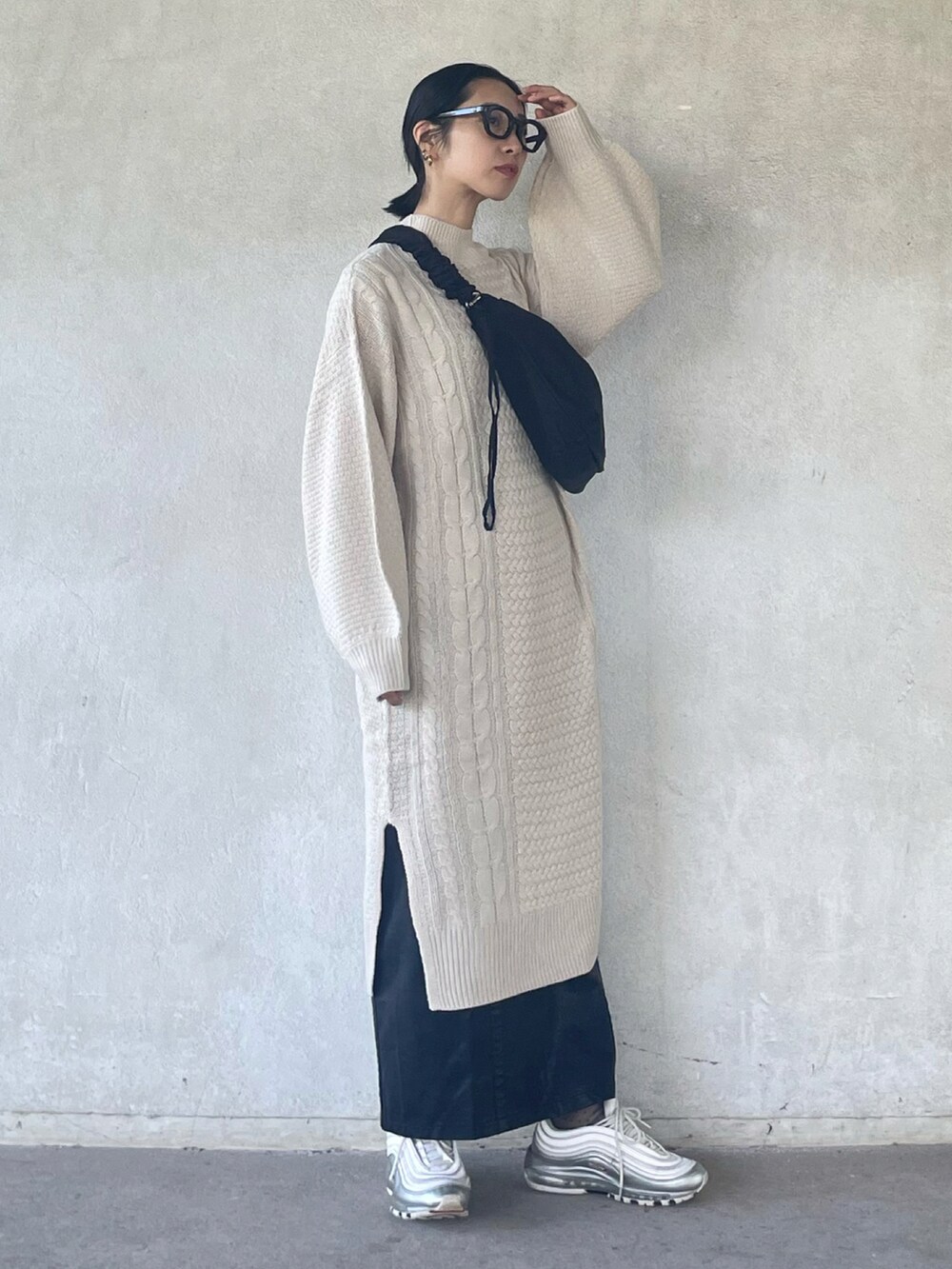 ホワイト系のワンピース、ブラック系のスカート、ブラック系のショルダーバッグを着用したレディースの秋コーディネートの3枚目の写真