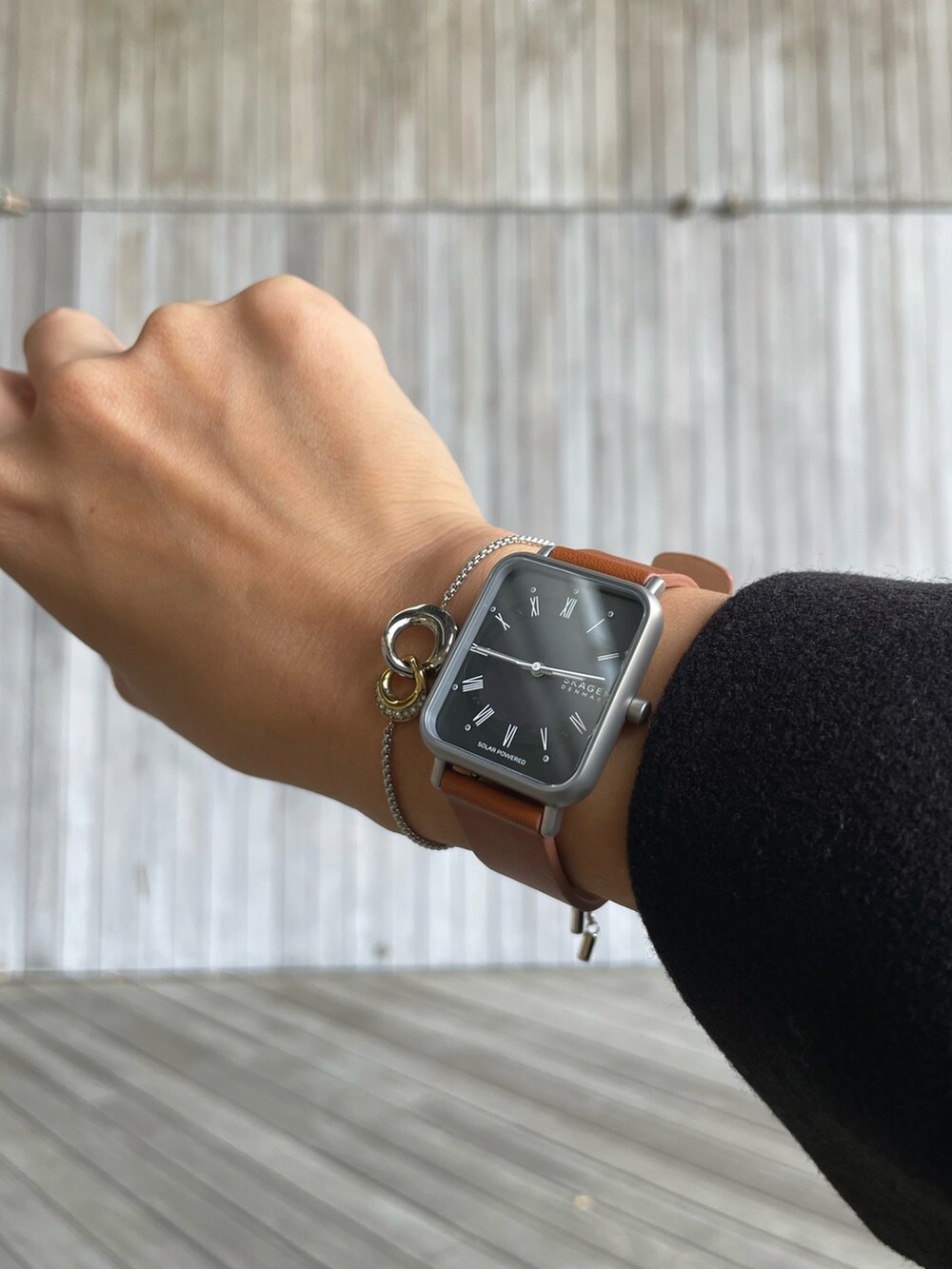 ブラック系のチェスターコート、ブラック系のワンピース、グリーン系のニット/セーターを着用したレディースの秋コーディネートの3枚目の写真