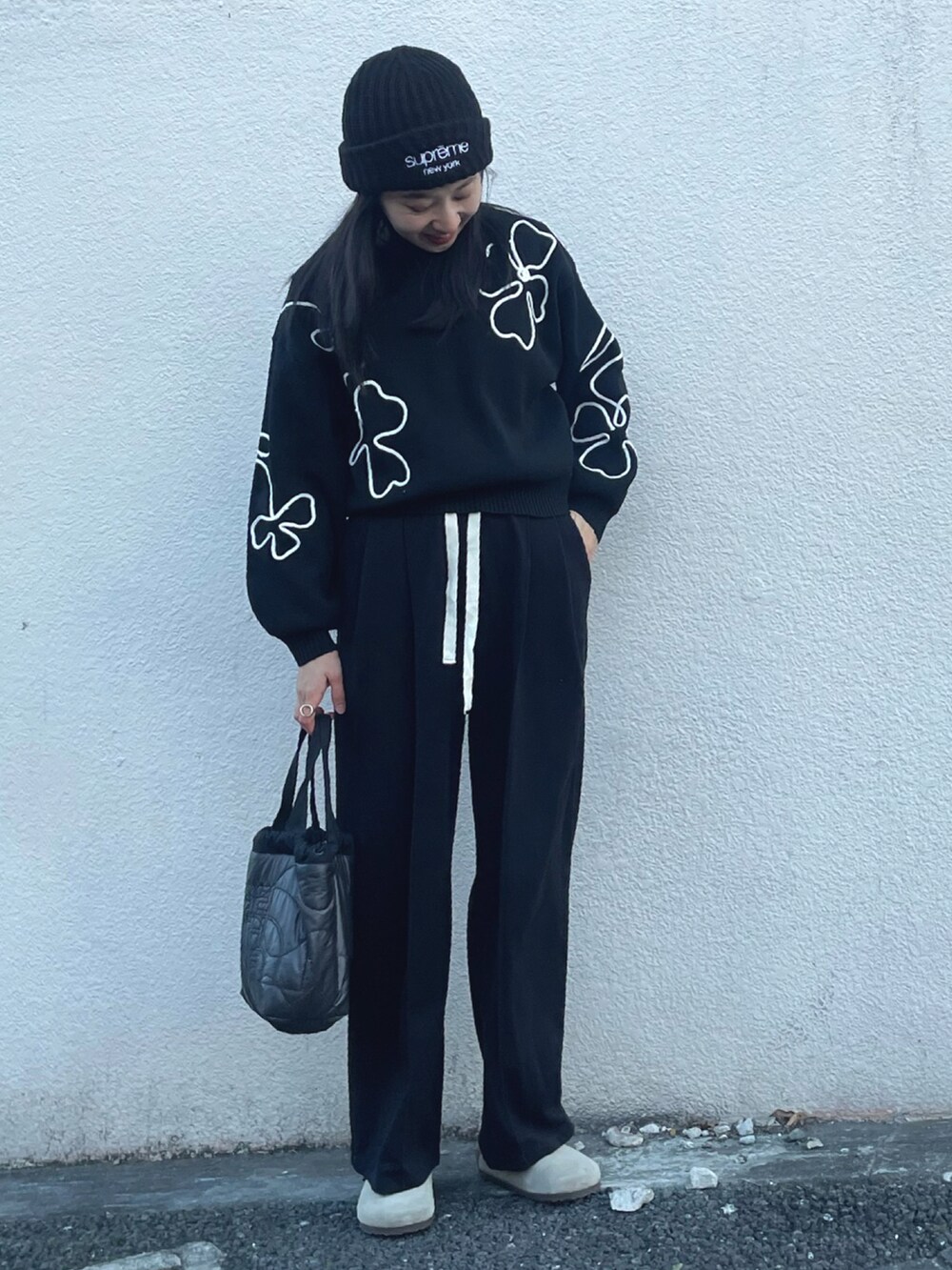 ブラック系のニット/セーター、ブラック系のスウェットパンツ、ベージュ系のサンダルを着用したレディースの冬コーディネートの5枚目の写真