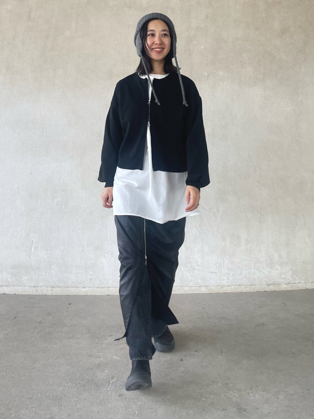 ブラック系のカーディガン/ボレロ、ホワイト系のシャツ/ブラウス、ブラック系のスカートを着用したレディースの冬コーディネートの2枚目の写真