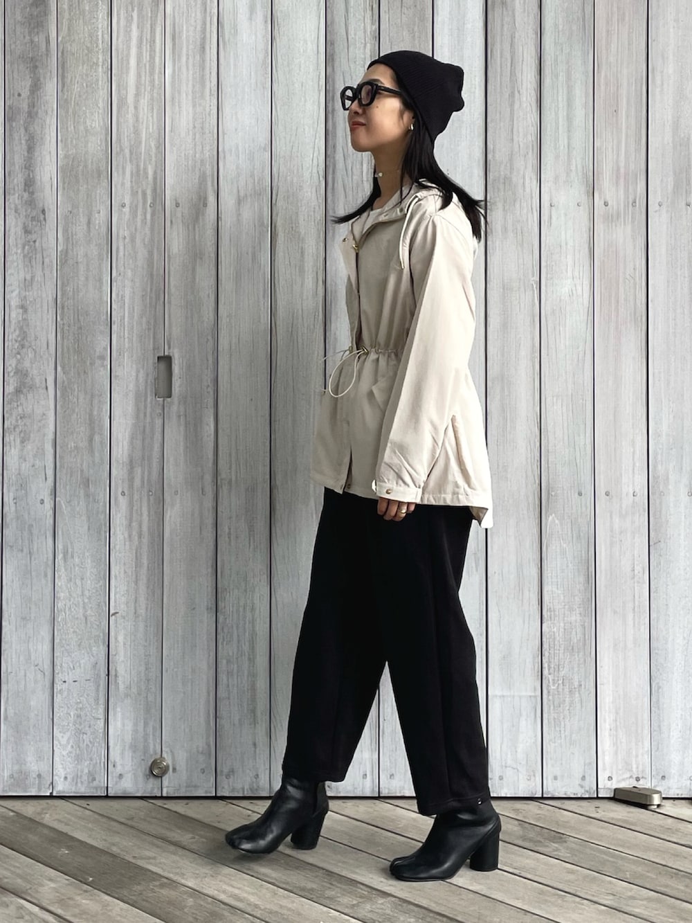 ベージュ系のマウンテンパーカー、ブラック系のスウェットパンツ、ブラック系のショルダーバッグを着用したレディースの秋コーディネートの5枚目の写真