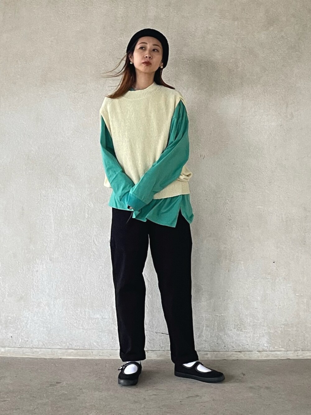 ホワイト系のベスト、グリーン系のTシャツ/カットソー、ブラック系のカーゴパンツを着用したレディースの秋コーディネートの3枚目の写真