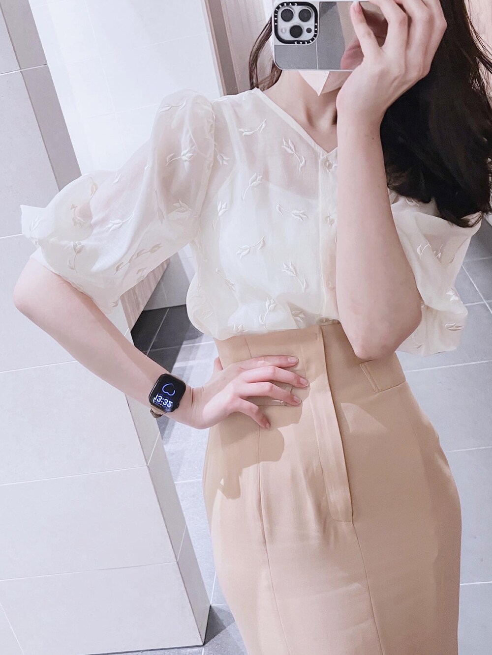 ベージュ系のトップス、オレンジ系のスカートを着用したレディースの春コーディネートの2枚目の写真