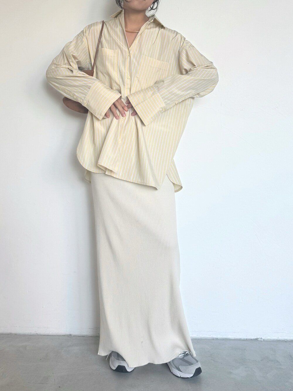 イエロー系のシャツ/ブラウス、ホワイト系のスカート、グレー系のスニーカーを着用したレディースの冬コーディネートの2枚目の写真