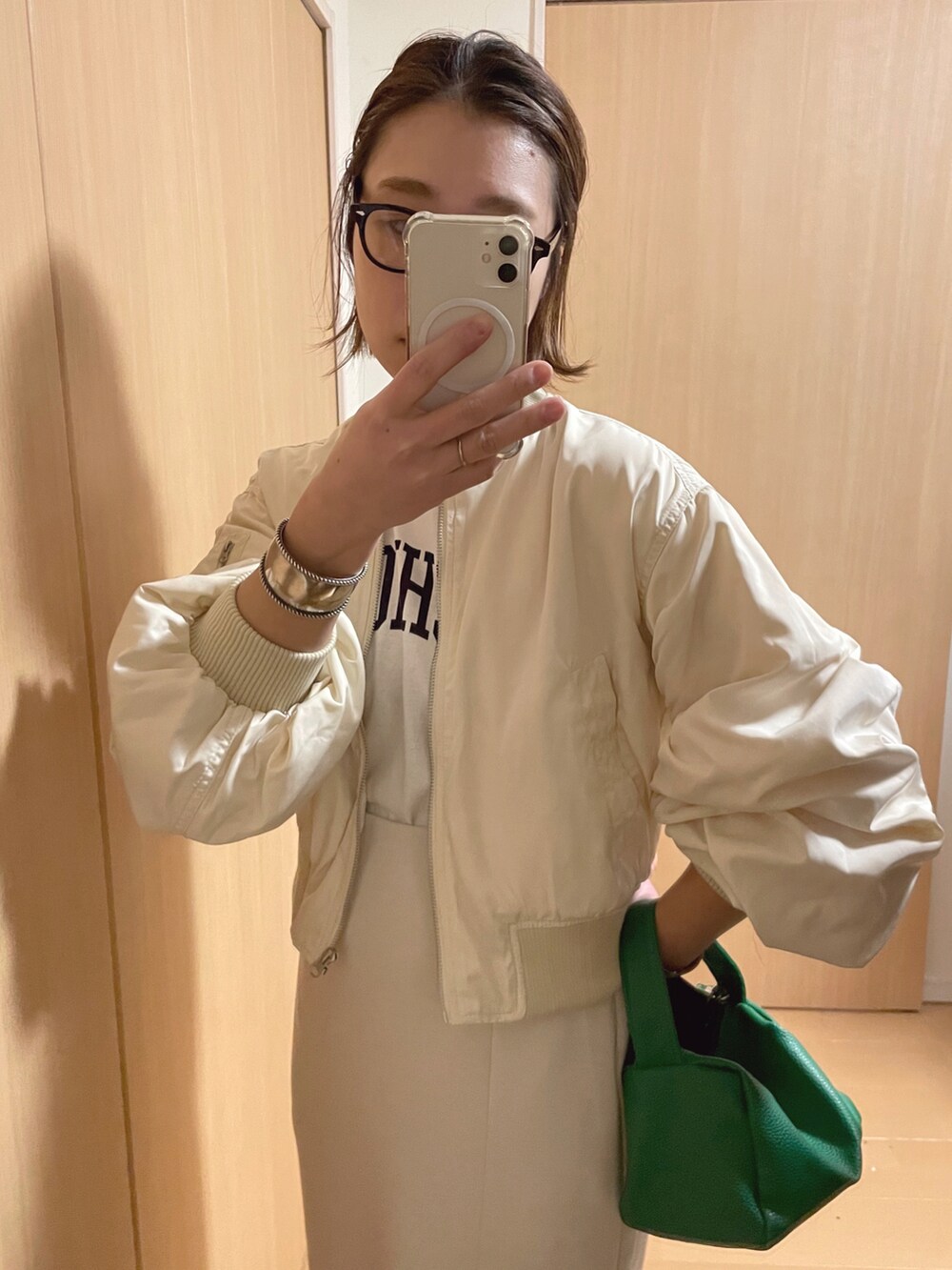 ホワイト系のブルゾン、グレー系のスカート、ホワイト系のスニーカーを着用したレディースの春コーディネートの2枚目の写真