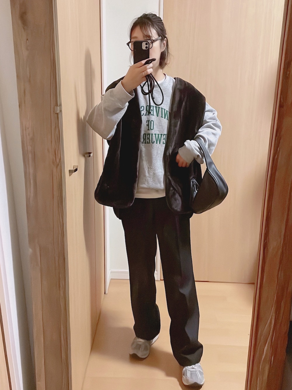 グレー系のスウェット、ブラック系のモッズコート、グレー系のスニーカーを着用したレディースの秋コーディネートの2枚目の写真