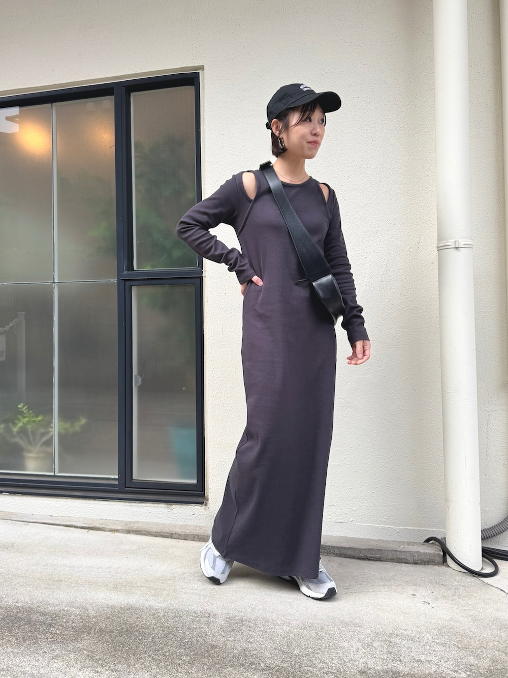 ブラック系のショルダーバッグ、グレー系のスニーカー、ブラック系のワンピースを着用したレディースの冬コーディネートの4枚目の写真