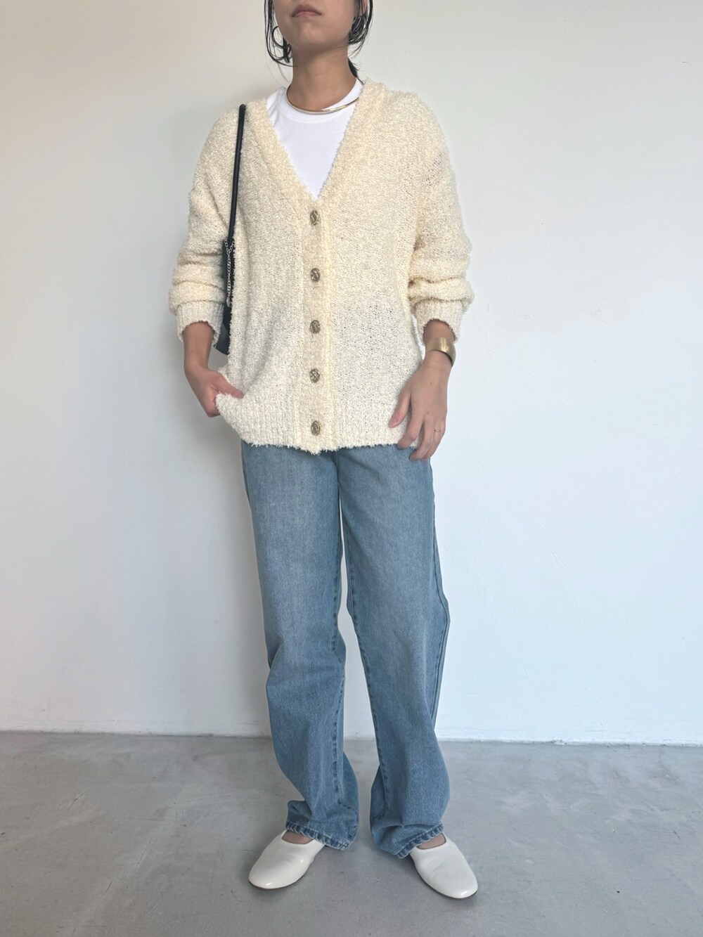 ブルー系のデニムパンツ、ホワイト系のカーディガン/ボレロを着用したレディースの冬コーディネートの4枚目の写真