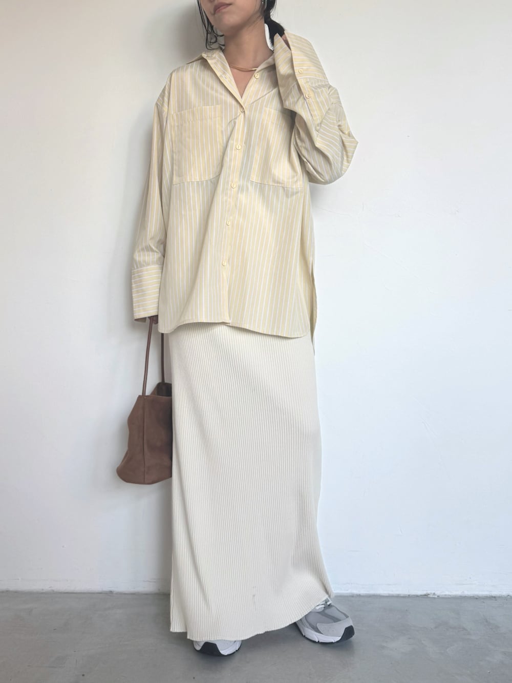 イエロー系のシャツ/ブラウス、ホワイト系のスカート、グレー系のスニーカーを着用したレディースの冬コーディネートの3枚目の写真