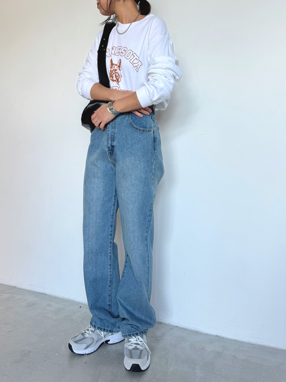 ブルー系のデニムパンツ、グレー系のスニーカー、ホワイト系のTシャツ/カットソーを着用したレディースの冬コーディネートの2枚目の写真