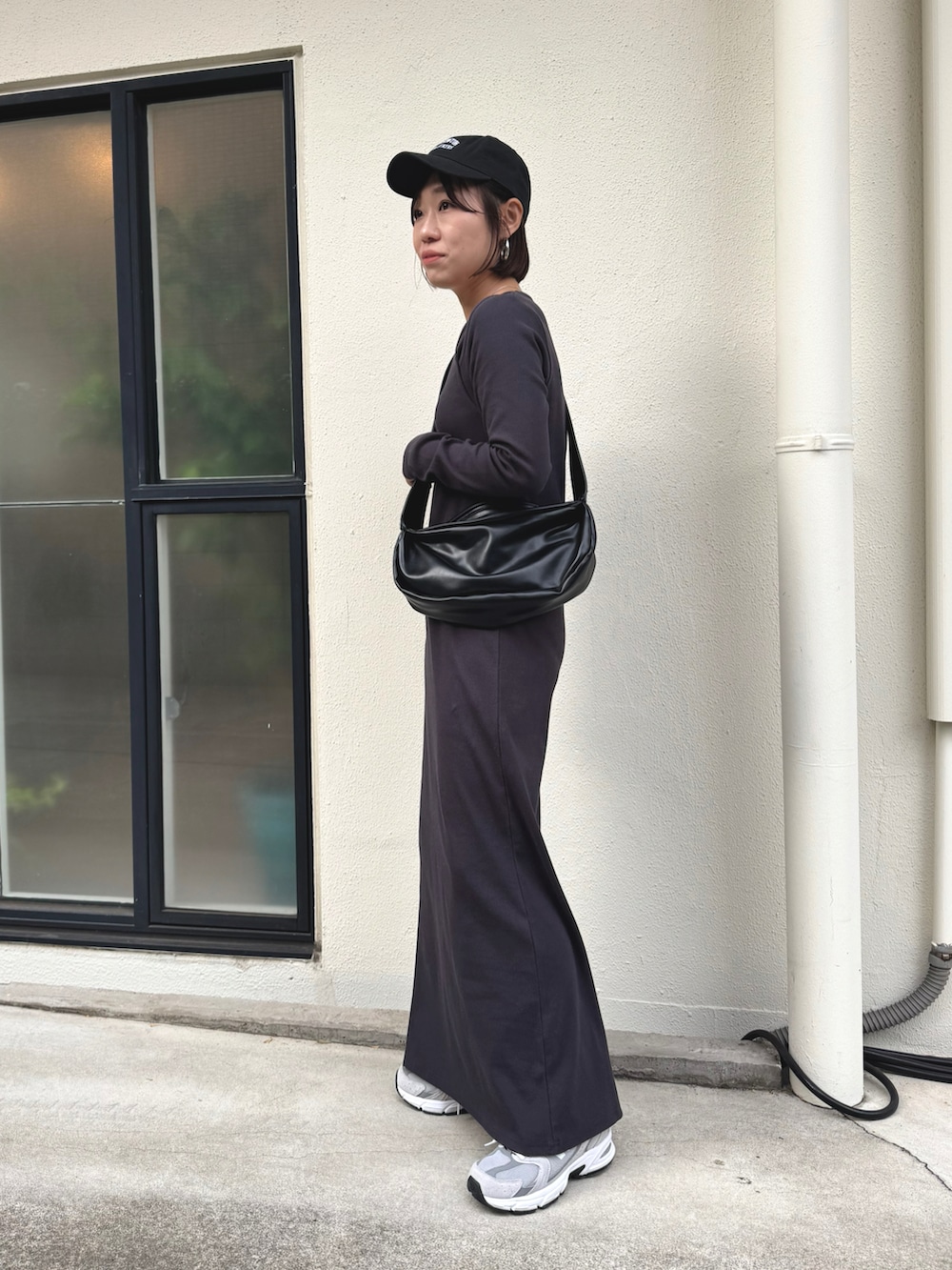 ブラック系のショルダーバッグ、グレー系のスニーカー、ブラック系のワンピースを着用したレディースの冬コーディネートの3枚目の写真