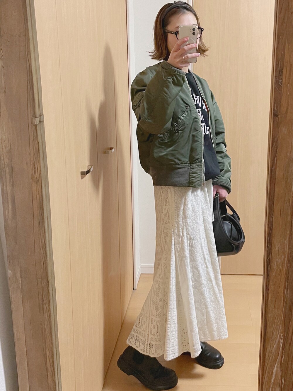 ブラック系のスウェット、グリーン系のMA-1、ブラック系のブーツを着用したレディースの冬コーディネートの2枚目の写真