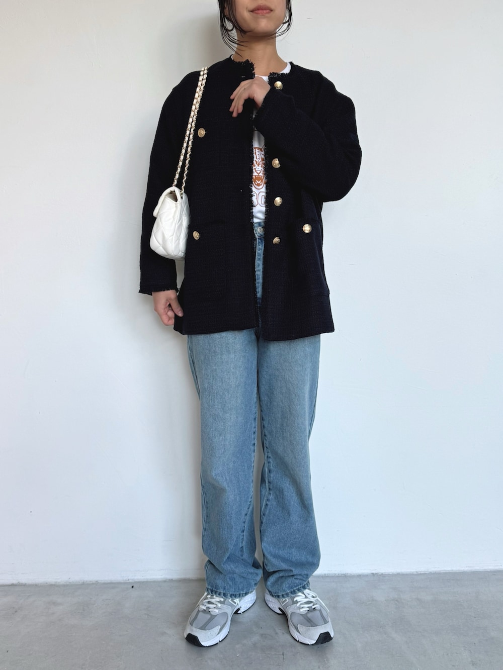 ブルー系のデニムパンツ、グレー系のスニーカー、ブルー系のノーカラージャケットを着用したレディースの冬コーディネートの3枚目の写真