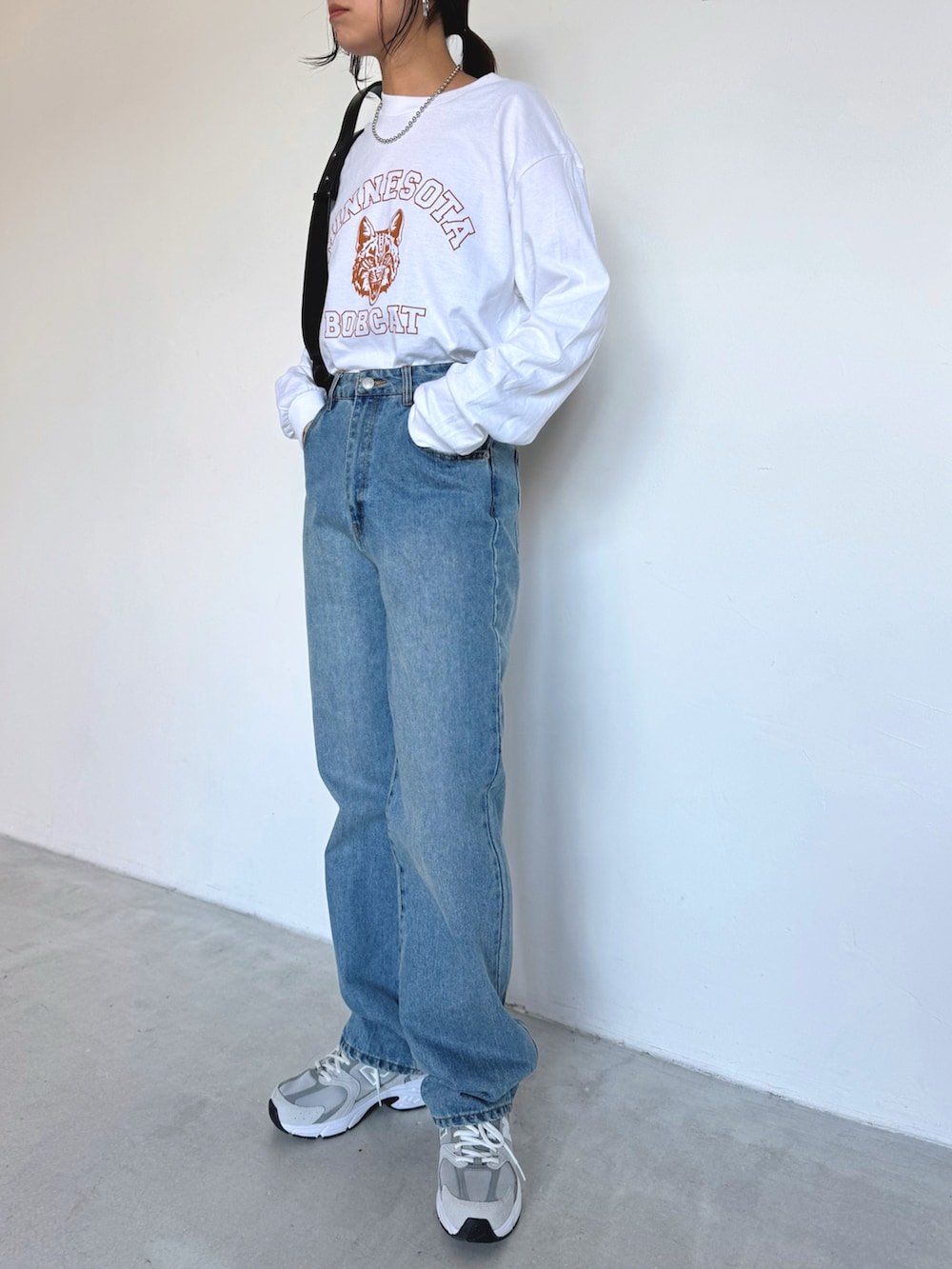 ブルー系のデニムパンツ、グレー系のスニーカー、ホワイト系のTシャツ/カットソーを着用したレディースの冬コーディネートの3枚目の写真