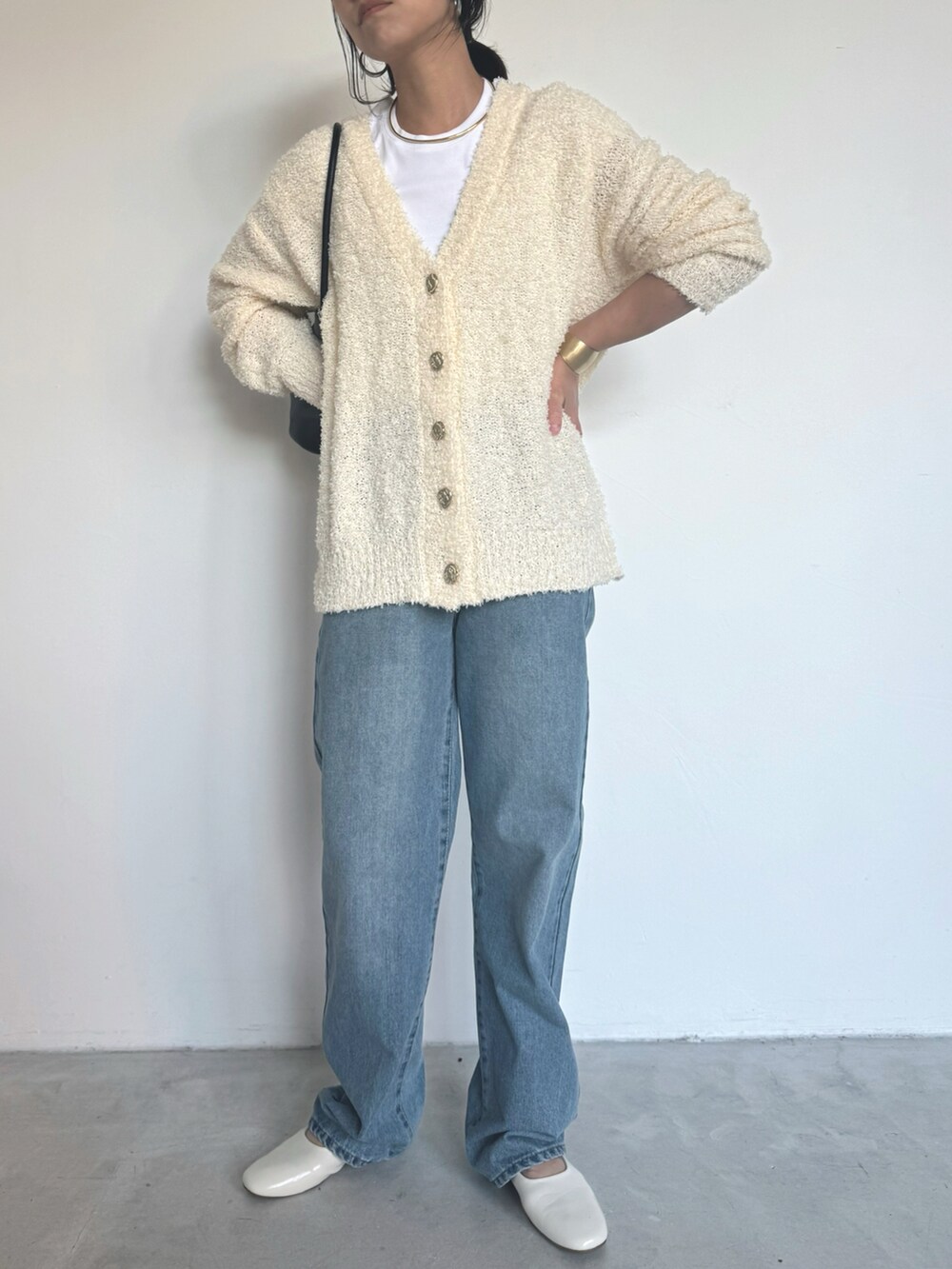 ブルー系のデニムパンツ、ホワイト系のカーディガン/ボレロを着用したレディースの冬コーディネートの2枚目の写真