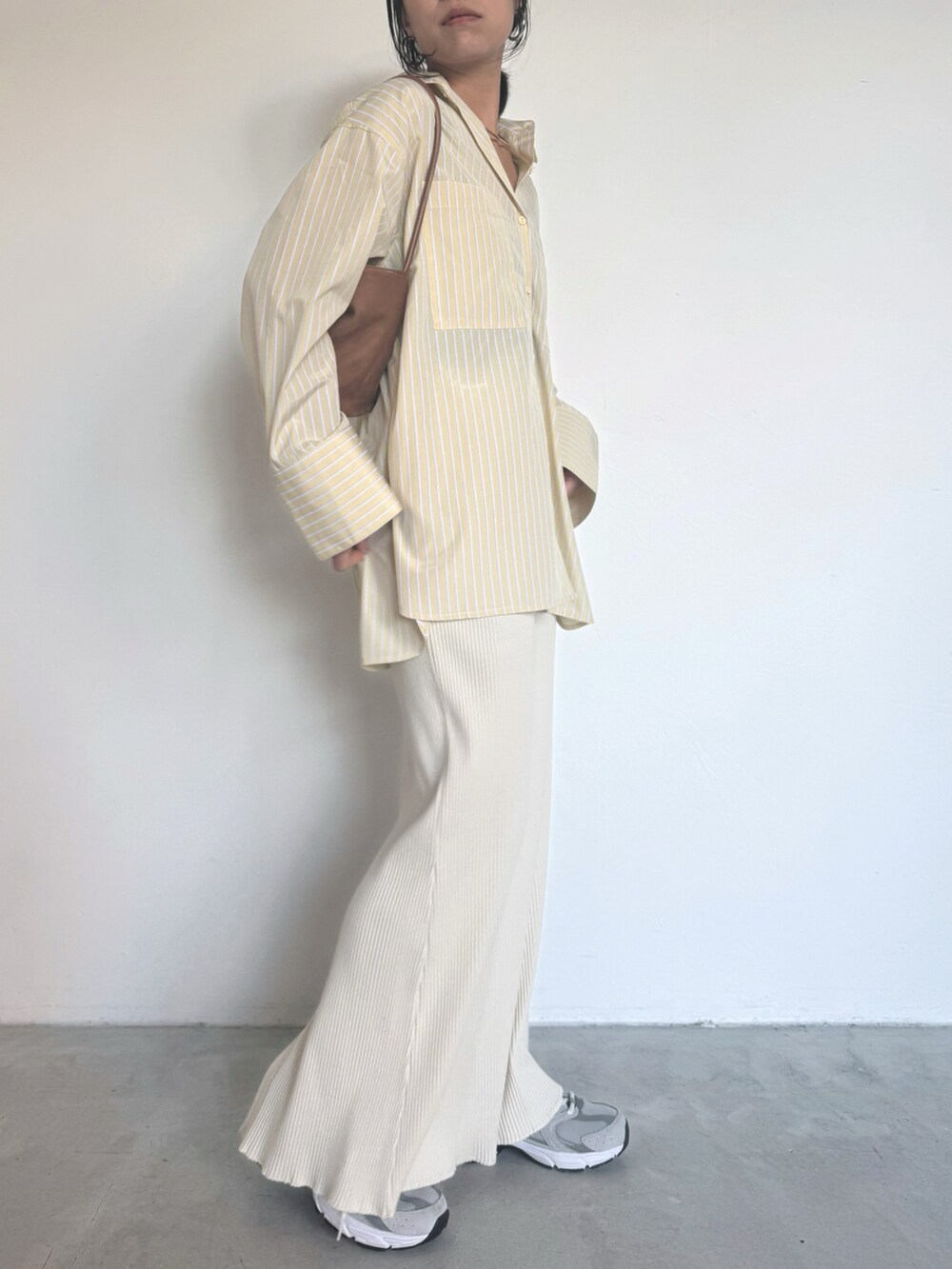 イエロー系のシャツ/ブラウス、ホワイト系のスカート、グレー系のスニーカーを着用したレディースの冬コーディネートの4枚目の写真