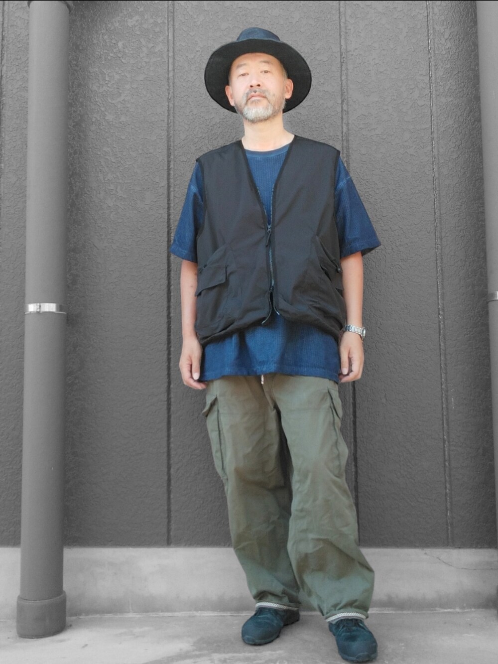 グリーン系のカーゴパンツ、ブラック系のスニーカー、ブルー系のTシャツ/カットソーを着用したメンズの夏コーディネートの3枚目の写真