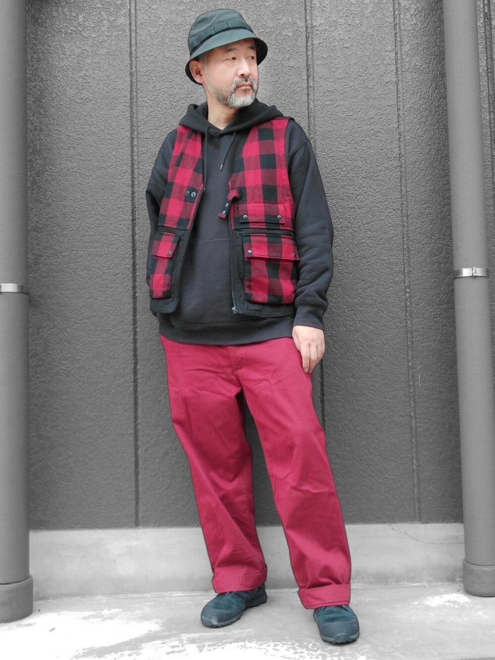 レッド系のチノパンツ、ブラック系のスニーカー、レッド系のその他アウターを着用したメンズの秋コーディネートの3枚目の写真