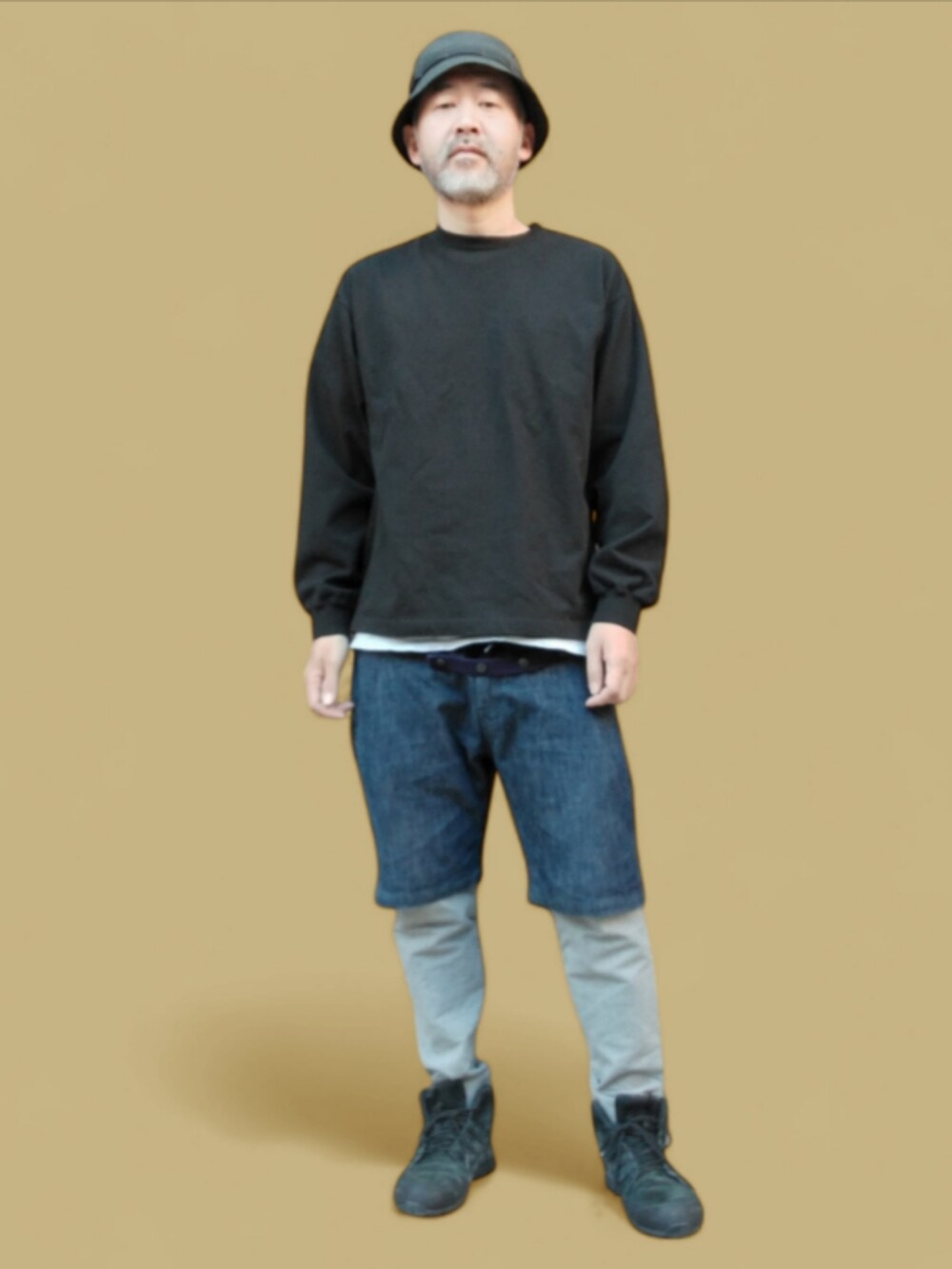 ブルー系のデニムパンツ、ブラック系のスニーカー、ブラック系のハットを着用したメンズの秋コーディネートの2枚目の写真