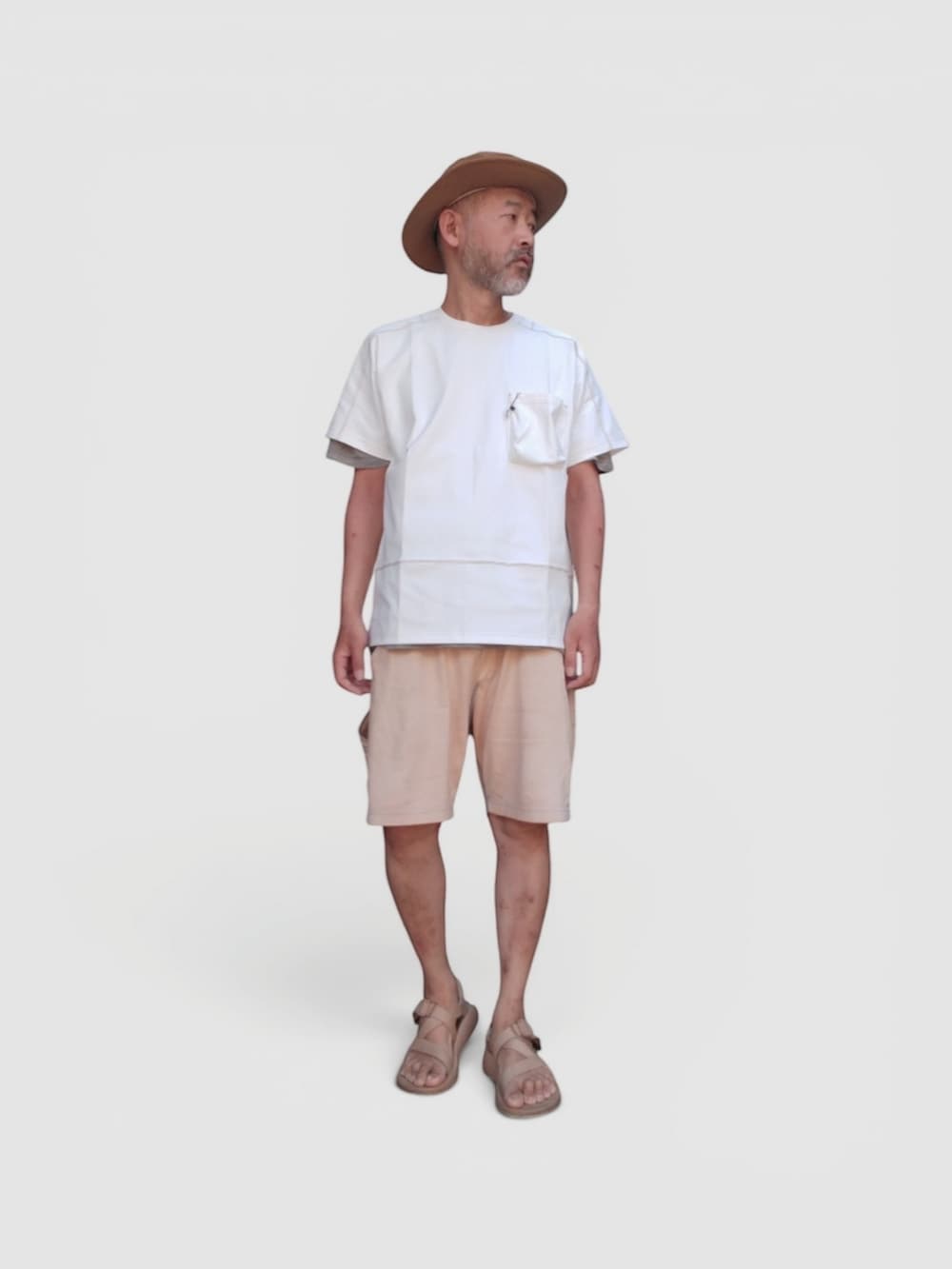 イエロー系のパンツ、ベージュ系のサンダル、ホワイト系のTシャツ/カットソーを着用したメンズの夏コーディネートの3枚目の写真