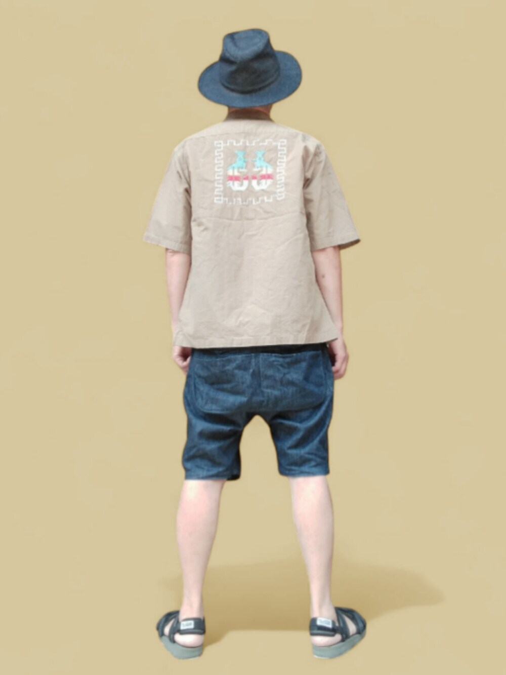 ブルー系のデニムパンツ、ブラック系のサンダル、ベージュ系のシャツ/ブラウスを着用したメンズの夏コーディネートの5枚目の写真