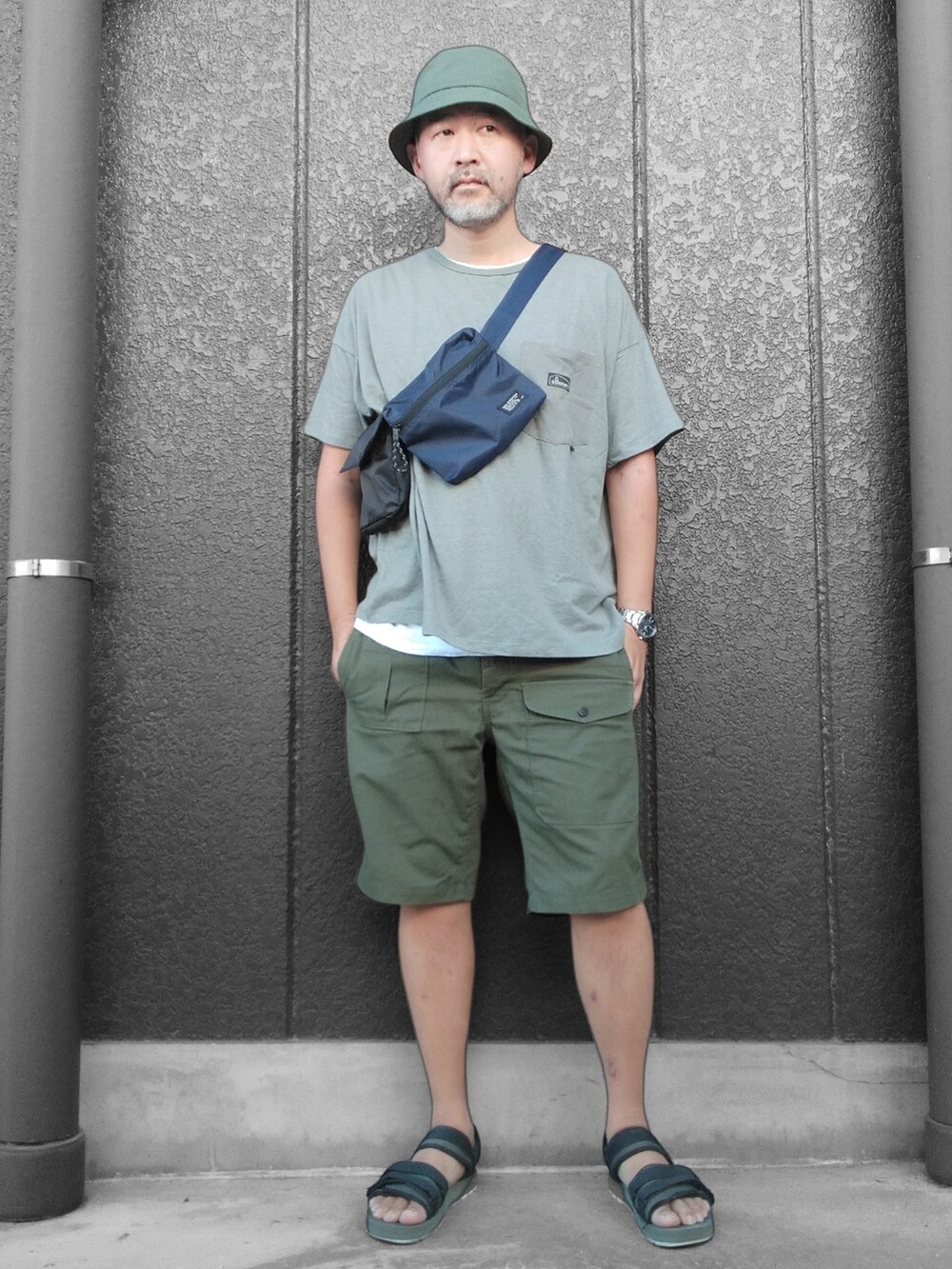 グリーン系のTシャツ/カットソー、ブルー系のボディバッグ/ウエストポーチ、グリーン系のその他パンツを着用したメンズの夏コーディネートの2枚目の写真