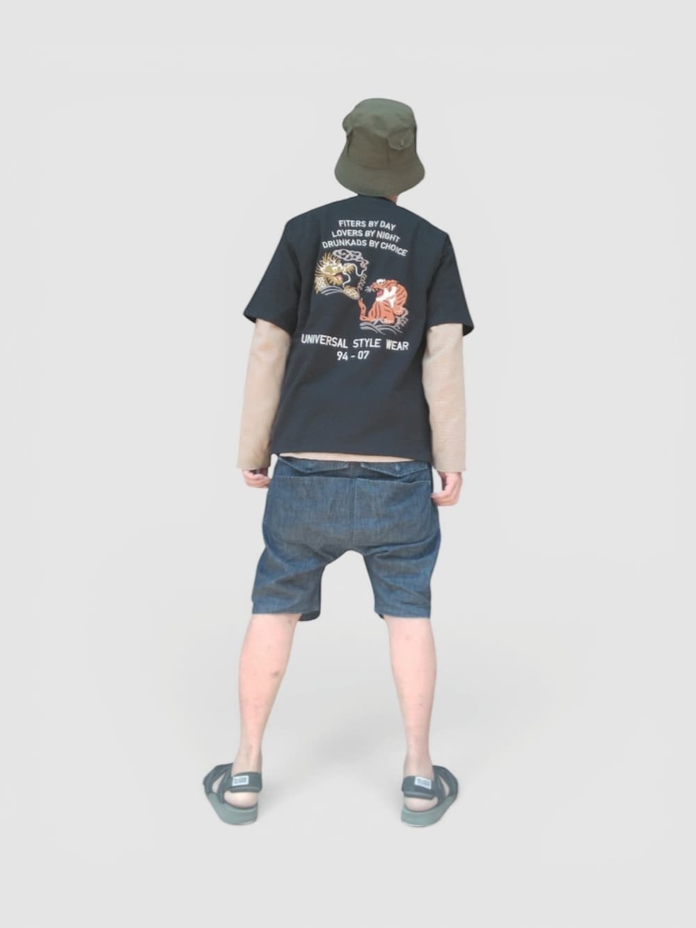 ブルー系のデニムパンツ、ブラック系のサンダル、ブラック系のTシャツ/カットソーを着用したメンズの夏コーディネートの5枚目の写真